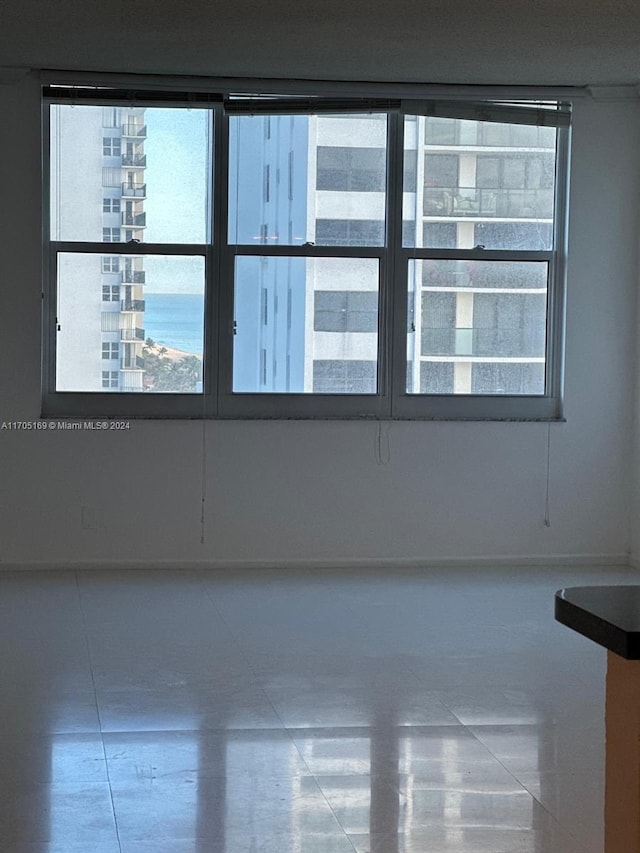 spare room featuring tile patterned flooring and a water view