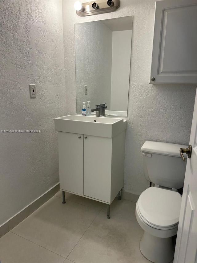 bathroom featuring tile patterned flooring, vanity, and toilet