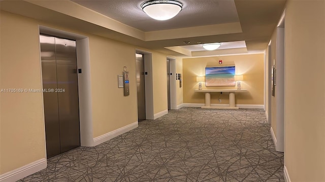 corridor with a raised ceiling and elevator