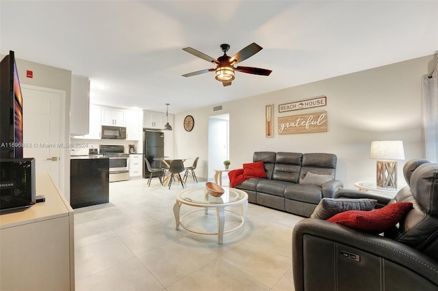 living room featuring ceiling fan and light tile patterned flooring