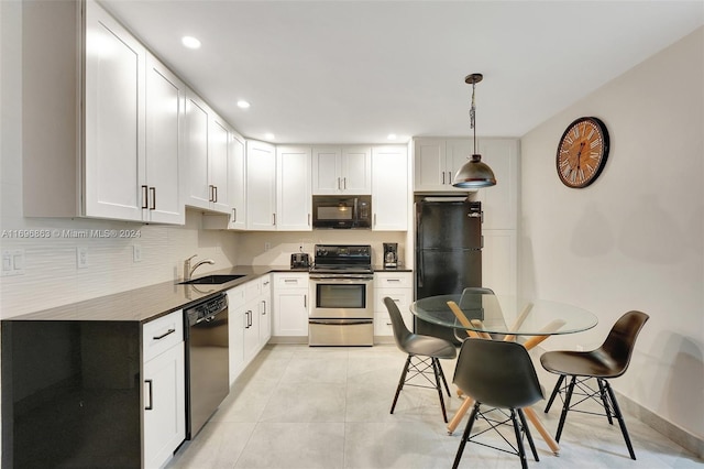 kitchen with sink, light tile patterned floors, decorative light fixtures, white cabinets, and black appliances