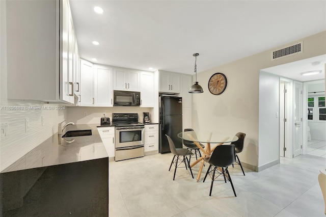 kitchen with sink, hanging light fixtures, light tile patterned floors, white cabinets, and black appliances