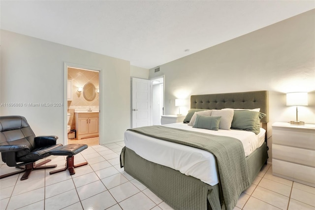 tiled bedroom featuring ensuite bathroom and sink