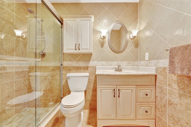 bathroom featuring vanity, toilet, and tile walls