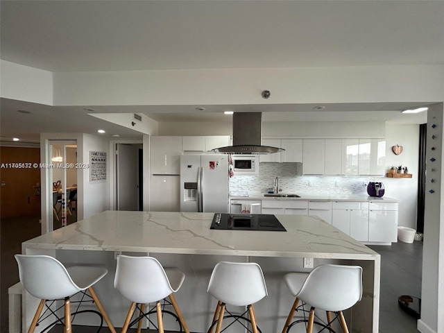 kitchen featuring island range hood, a spacious island, sink, white cabinets, and stainless steel fridge with ice dispenser