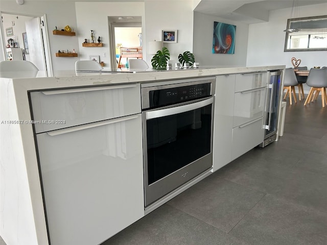 kitchen with stainless steel oven and white cabinetry