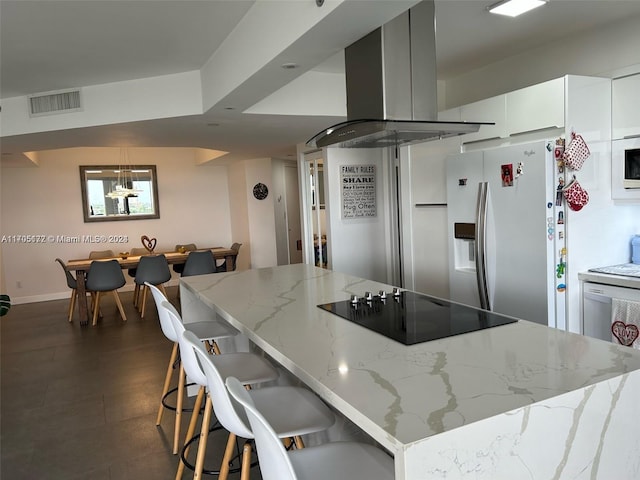 kitchen featuring white cabinetry, wall chimney exhaust hood, stainless steel fridge with ice dispenser, light stone counters, and black electric cooktop