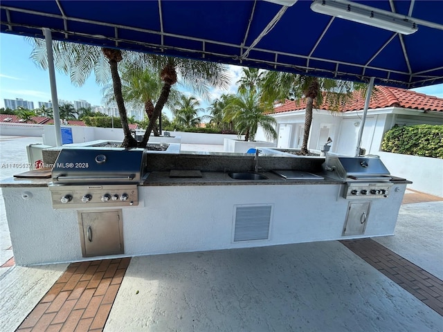 view of patio / terrace with a grill, area for grilling, and sink