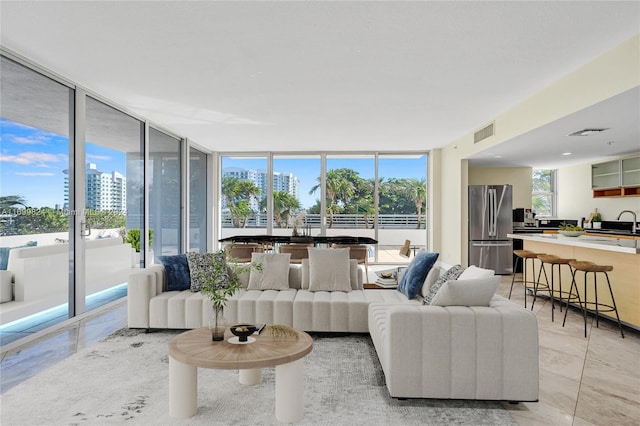 living room featuring sink and a wall of windows