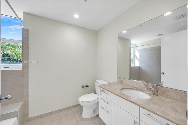 bathroom with tiled shower, vanity, tile patterned floors, and toilet