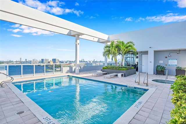 view of swimming pool with a patio area and a hot tub