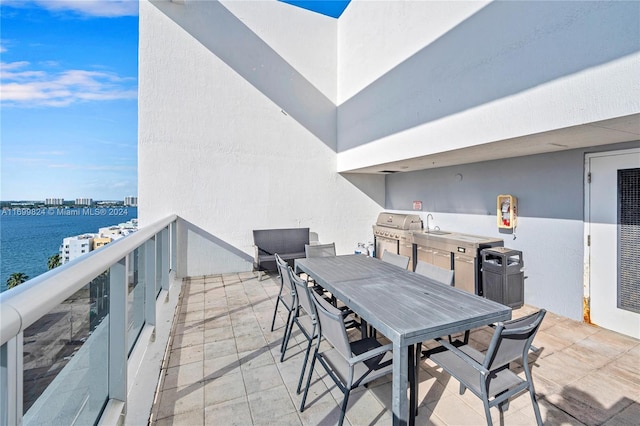 view of patio / terrace with a water view, grilling area, a balcony, and sink