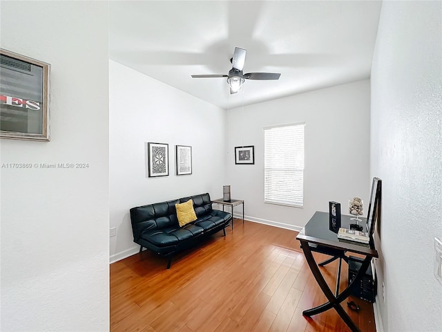 sitting room with ceiling fan and hardwood / wood-style floors