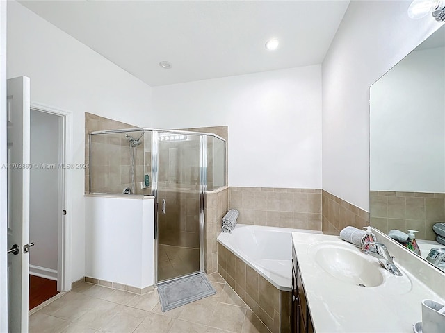 bathroom with tile patterned flooring, vanity, and shower with separate bathtub