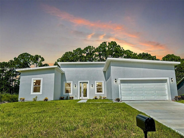 view of front of home featuring a garage and a lawn