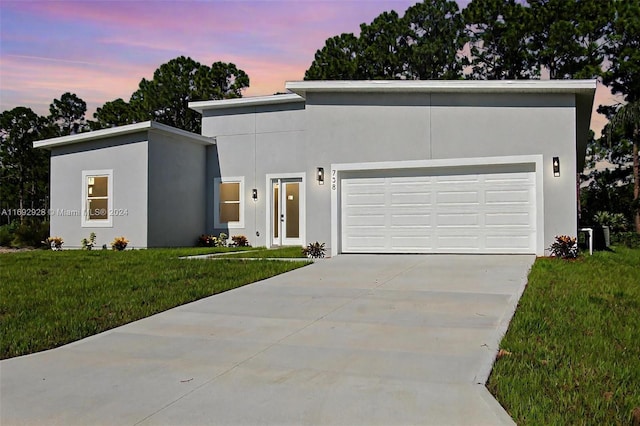 modern home featuring a garage and a lawn