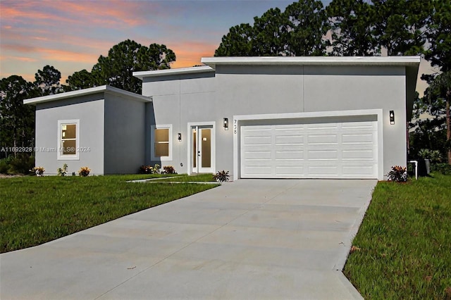 contemporary home featuring a lawn and a garage