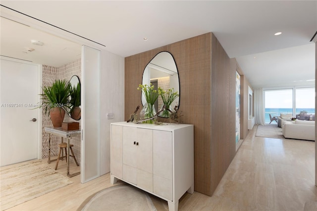 hallway featuring light hardwood / wood-style floors and a wall of windows