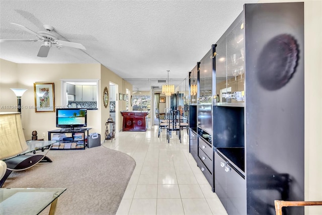 living room with ceiling fan, tile patterned flooring, and a textured ceiling