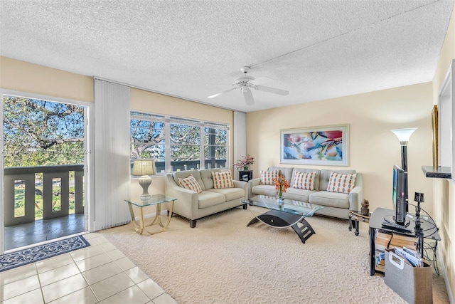 living room with ceiling fan, light tile patterned floors, and a textured ceiling