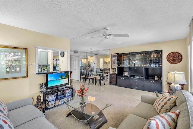 living room featuring tile patterned floors, ceiling fan, and a textured ceiling