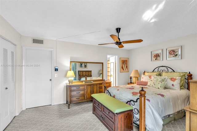 carpeted bedroom featuring ceiling fan, a closet, and a textured ceiling