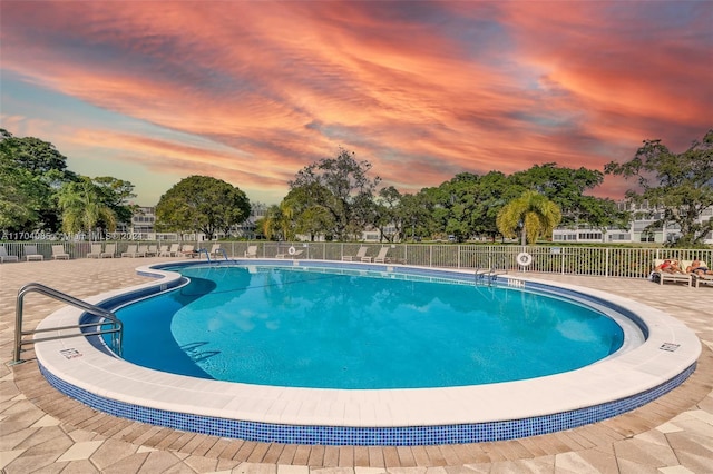 pool at dusk with a patio