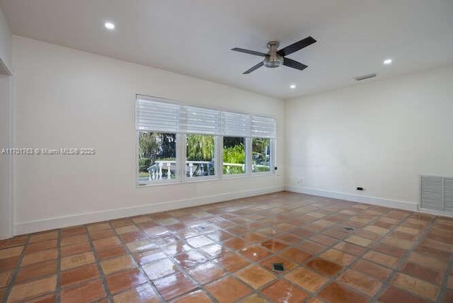 tiled spare room with ceiling fan