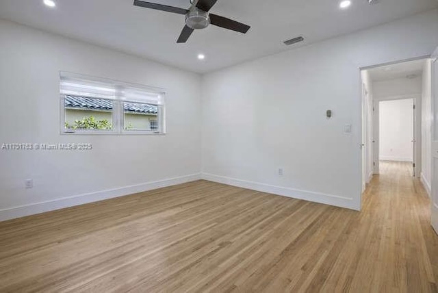 empty room with ceiling fan and light hardwood / wood-style flooring