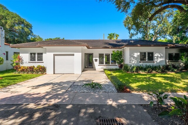 511 Madeira Ave, Coral Gables, FL 33134 - ranch-style home with an attached garage, stucco siding, a front yard, and concrete driveway