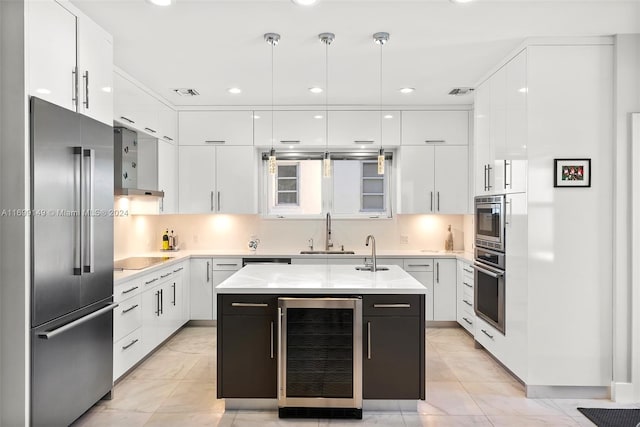 kitchen featuring built in appliances, white cabinets, a kitchen island, and beverage cooler