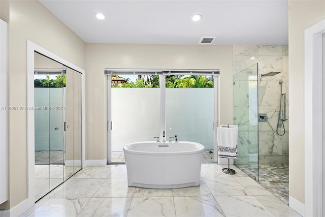 511 Madeira Ave, Coral Gables, FL 33134 - bathroom with marble tiled flooring, a marble finish shower, a soaking tub, recessed lighting, and baseboards