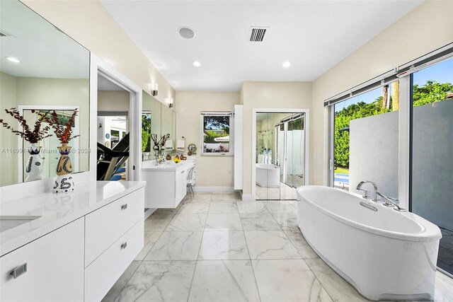 511 Madeira Ave, Coral Gables, FL 33134 - bathroom with two vanities, marble finish flooring, a soaking tub, a shower stall, and recessed lighting