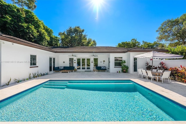 view of pool with ceiling fan, a patio area, and french doors