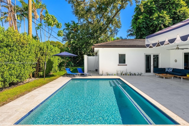 view of pool with outdoor lounge area, ceiling fan, a patio area, and french doors