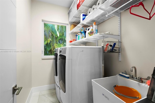 laundry room with independent washer and dryer, light tile patterned floors, and sink