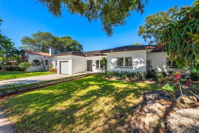 511 Madeira Ave, Coral Gables, FL 33134 - view of front facade with stucco siding, a garage, concrete driveway, a front yard, and a chimney