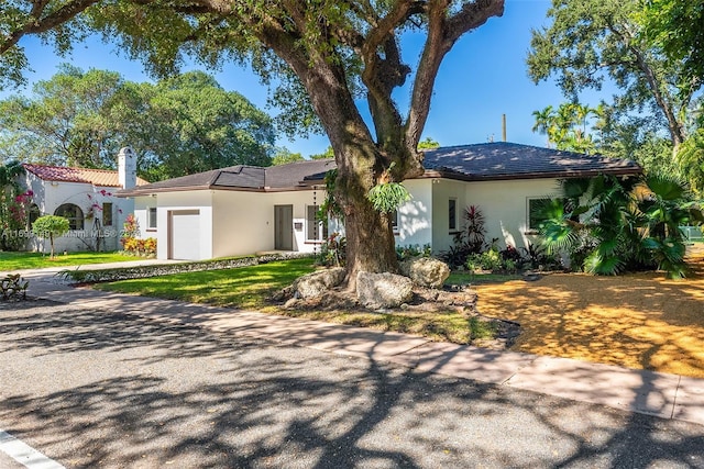 511 Madeira Ave, Coral Gables, FL 33134 - view of front of house featuring a garage, stucco siding, concrete driveway, a chimney, and a front yard
