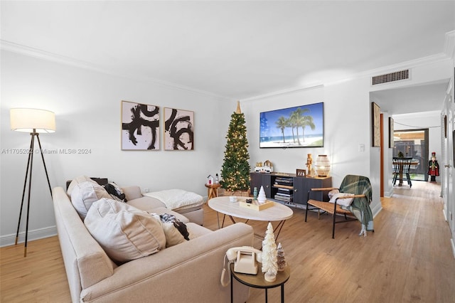 living room with light wood-type flooring and crown molding