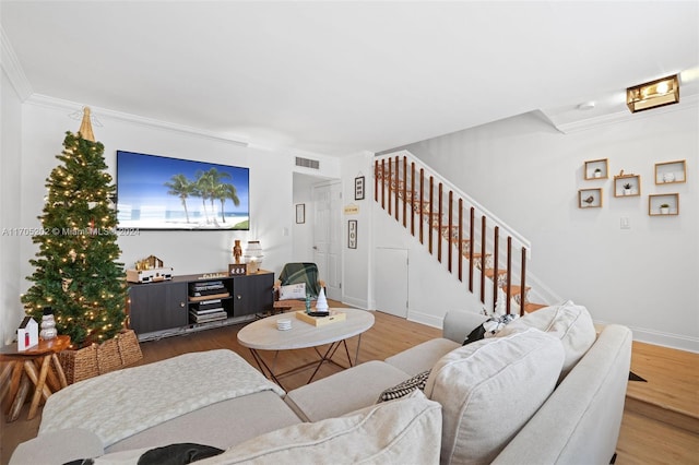 living room with wood-type flooring and ornamental molding