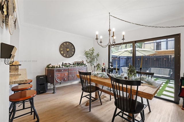 dining area featuring crown molding, a notable chandelier, and light wood-type flooring