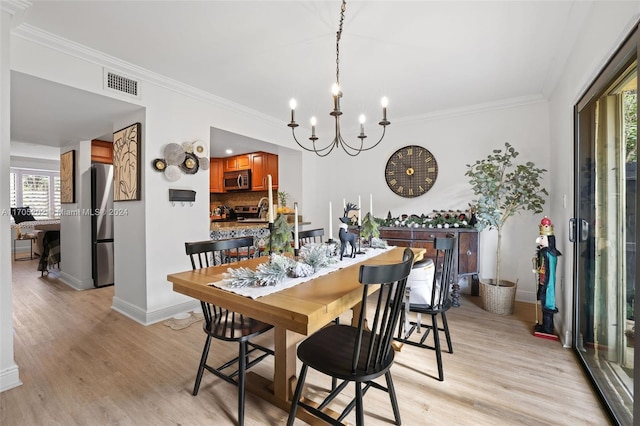 dining area featuring a notable chandelier, light hardwood / wood-style floors, and crown molding