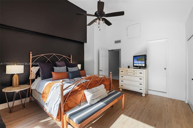 bedroom featuring wood-type flooring, high vaulted ceiling, and ceiling fan