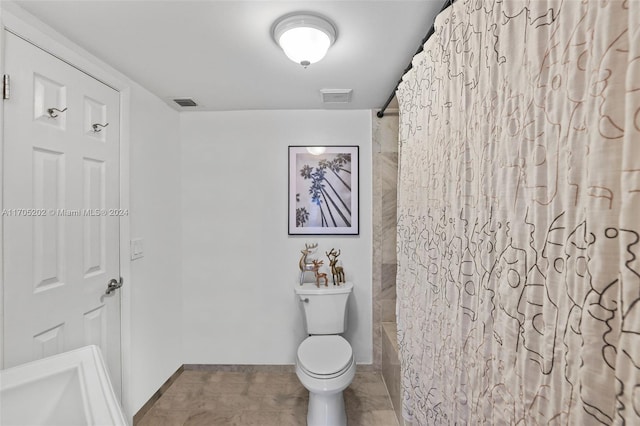 bathroom featuring tile patterned flooring, shower / bath combo, and toilet