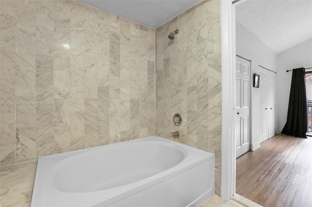 bathroom with hardwood / wood-style flooring and lofted ceiling