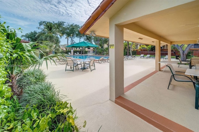 view of patio featuring ceiling fan and a community pool