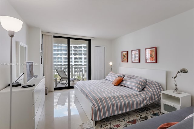 bedroom featuring access to exterior, light tile patterned floors, a closet, and floor to ceiling windows