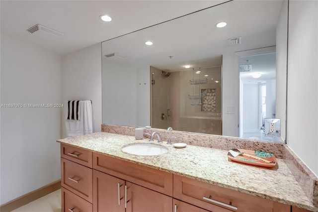 bathroom with vanity and a shower with door