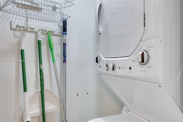 clothes washing area featuring stacked washing maching and dryer