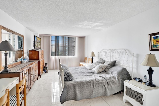 bedroom featuring light tile patterned floors and a textured ceiling